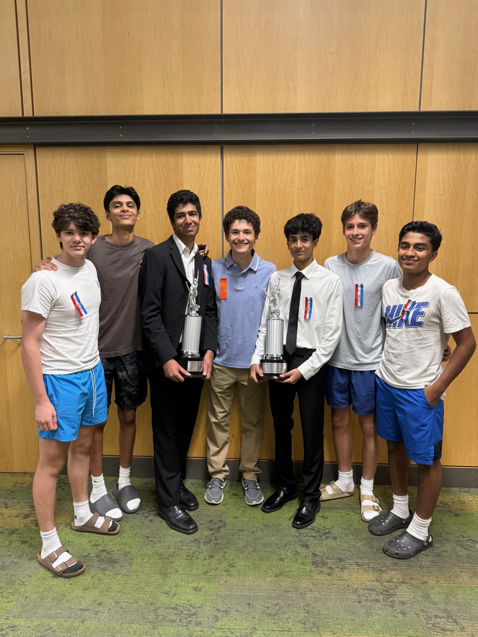 Debate team posing with trophies after a competition